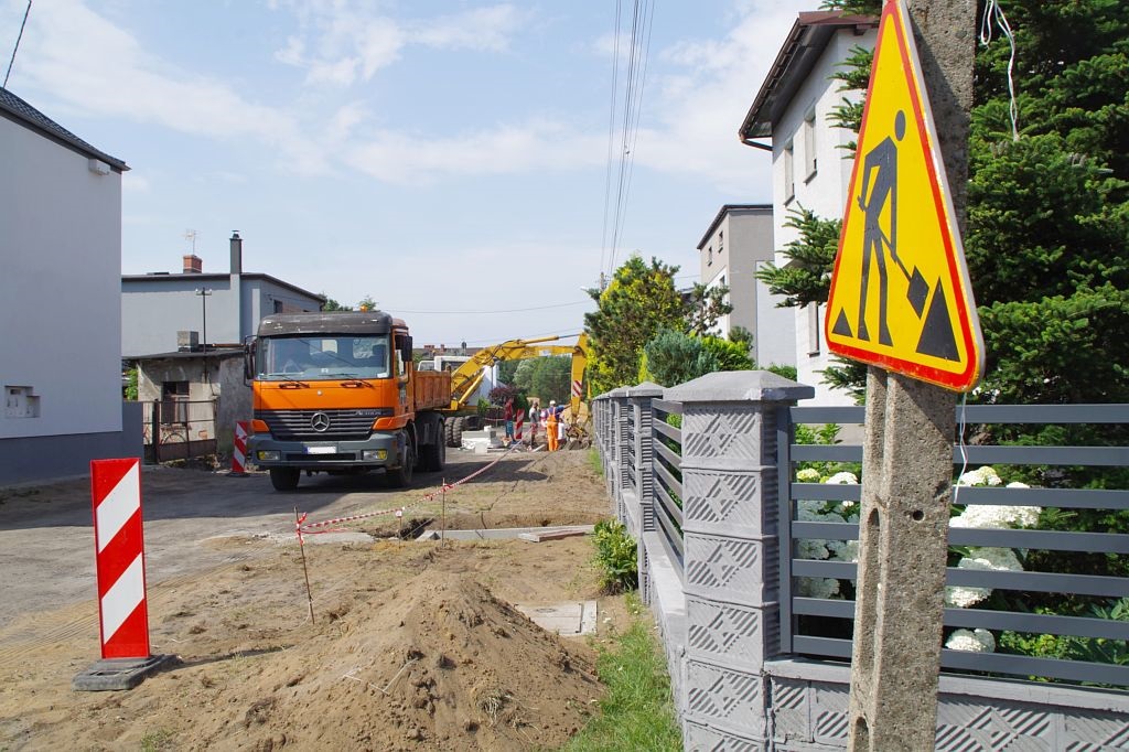 Fotografia przedstawia prace drogowe na ulicy brzozowej w Kaletach. Na zdjęciu koparka i samochód ciężarowy